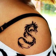 a woman with a dragon tattoo on her shoulder