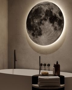 a bath room with a tub and a large moon on the wall above it's mirror