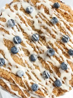 a blueberry crumb cake with white icing and fresh blueberries on top