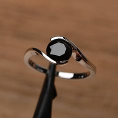 a black diamond ring sitting on top of a wooden table