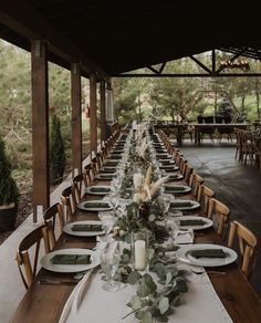 a long table is set with plates and place settings