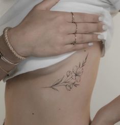 a woman's stomach with flowers on it and her hand resting on the side