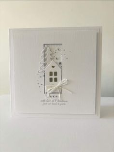 a white card with a house and trees on it