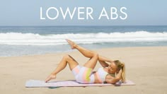 a woman laying on top of a towel in front of the ocean with text overlay that reads lower abs