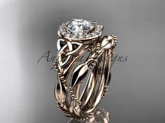 an intricately designed wedding ring set with a center stone surrounded by leaves and vines