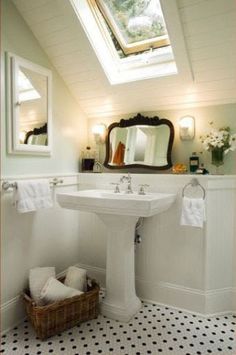 a white sink sitting under a bathroom mirror next to a window in a room with black and white tile flooring