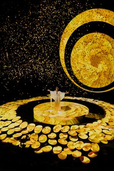 a man standing on top of a stage surrounded by golden circles and confetti