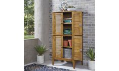 a tall wooden cabinet sitting next to a brick wall