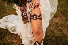 a woman with tattoos on her legs holding flowers in her hand and wearing cowboy boots