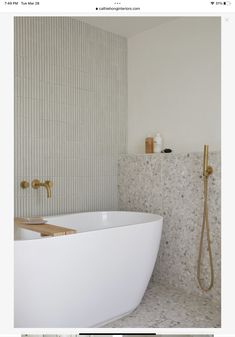 a white bath tub sitting next to a walk in shower under a faucet