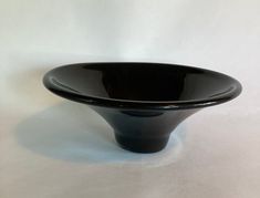 a black bowl sitting on top of a white table