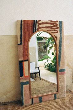 a mirror sitting on top of a rug next to a wall