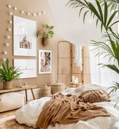 a bedroom with plants and pictures on the wall