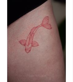 a woman's thigh with a fish tattoo on it