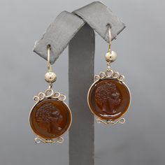 "Late Victorian Glass Cameo Dangle Earrings in 14k Yellow Gold While depicting a man's face, these earrings are actually very feminine with dangles and the looped gold.  The earrings feature a center round concave disk of amber colored glass which have an intricately detailed  man's face, complete with a curly head of hair.  The earrings close with ear wires that are stamped 14k. They measure 1 5/8\" in length including the hook and they are just under 3/4\" across.  They weigh 6.89g." Classic Intaglio Earrings As A Gift, Classic Intaglio Earrings For Formal Events, Classic Intaglio Earrings For Formal Occasions, Yellow Gold Round Intaglio Earrings, Yellow Gold Round Earrings With Intaglio, Vintage 14k Gold Earrings With Polished Finish, Collectible Yellow Gold Drop Earrings, Gold Cameo Drop Earrings, Cameo Drop Earrings For Formal Occasions