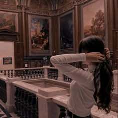 a woman with long hair standing in an ornate room