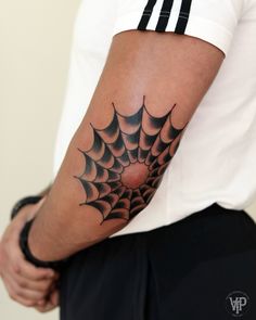 a man with a spider web tattoo on his arm