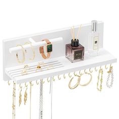 an assortment of jewelry hanging on a white shelf