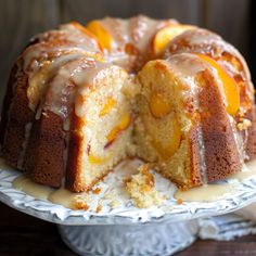 a bundt cake with peaches and icing sitting on a white platter