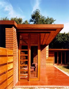 a wooden building with glass doors and brick walls