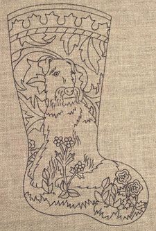 an embroidered stocking with a dog on it and flowers in the boot shape, is shown