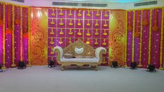 a stage set up for a wedding ceremony with pink and yellow decorations on the walls