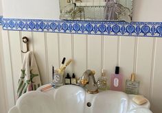 a white sink sitting under a bathroom mirror next to a wall mounted faucet