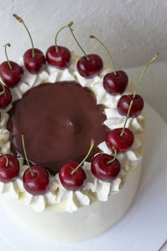 a cake with cherries and chocolate frosting on top