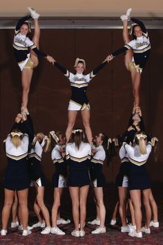 a group of cheerleaders standing in the middle of a circle with their hands up