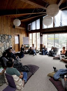 a group of people sitting on bean bags in a room with wood paneled walls