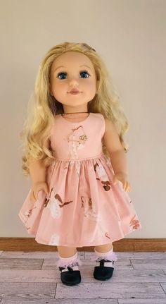 a doll with blonde hair wearing a pink dress and black shoes is standing on the floor