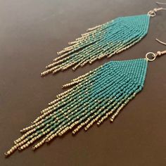 a pair of turquoise and gold beaded earrings