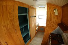 an inside view of a kitchen area with wooden cabinets and shelves on the side of the room