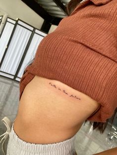 the back of a woman's stomach with her name tattooed on it