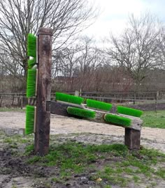 a wooden bench with green brushes on it