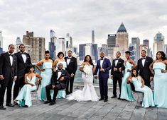 a large group of people in formal wear posing for a photo with the city skyline behind them