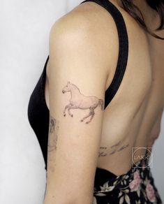 a woman with a horse tattoo on her left upper arm and right lower arm behind her back