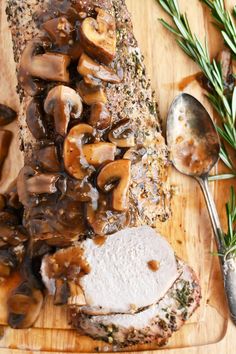 sliced meat with mushrooms and gravy on a cutting board