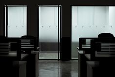 an empty room with glass doors and chairs