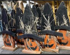 several pumpkin heads are sitting on wooden boards