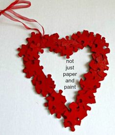 a red heart shaped puzzle with the words not just paper and paint