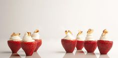 several strawberries with whipped cream on them are arranged in the shape of an arrow