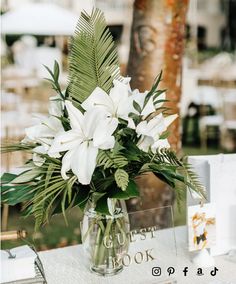 a vase filled with white flowers sitting on top of a table next to other items