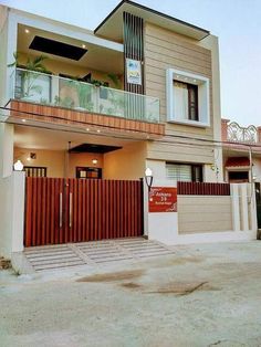 an apartment building with a red gate and balcony on the second floor that has balconies above it