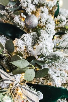 a decorated christmas tree with silver and white ornaments