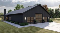 a garage with two cars parked in front of it on top of a grass covered field