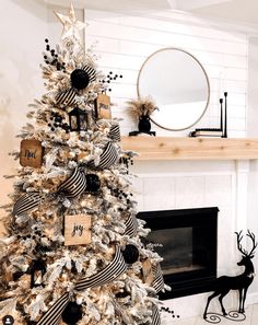 a decorated christmas tree in front of a fireplace with black and white decorations on it