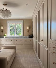 a large room with white cabinets and a chandelier