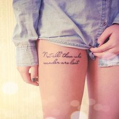 a woman's thigh with a tattoo that reads, not all those who wander are lost