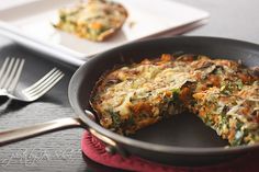 a pan with some food in it on a table next to a fork and knife